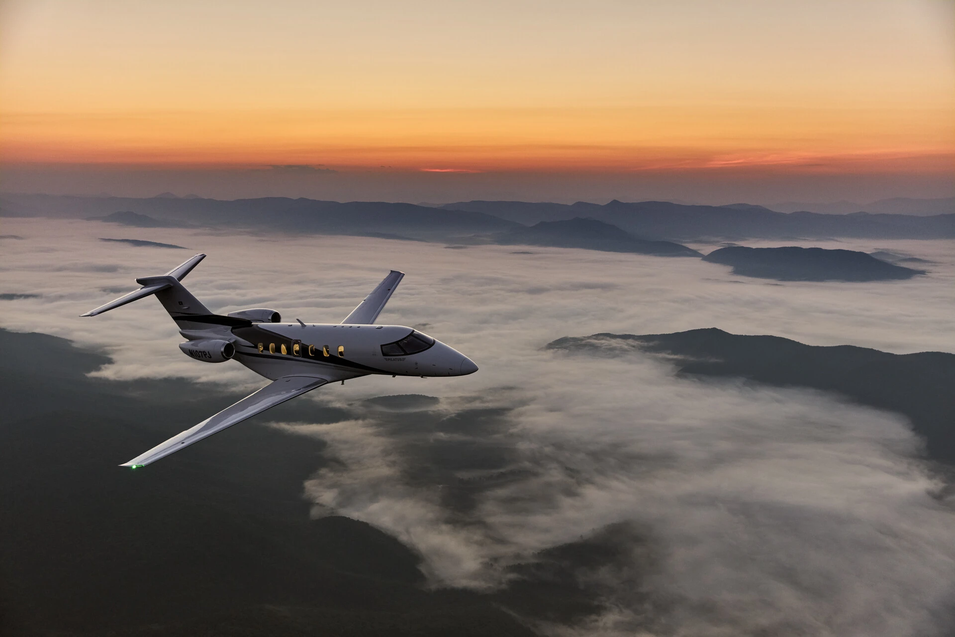 Private jet flying at sunset